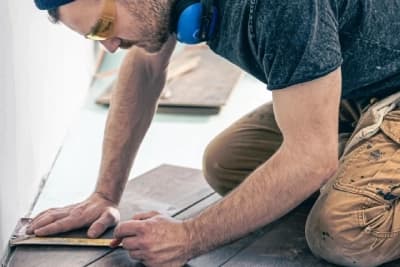 Bâtiment Ouvrier en train de réparer une cloison murale
